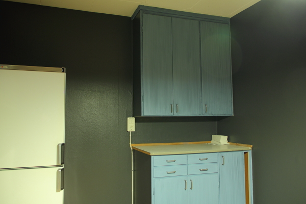 A small kitchen without owen or stove, but with a small fridge